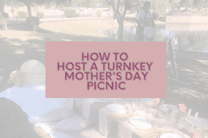 photo of picnic set up in a park near a lake with text "how to host a turnkey mother's day picnic"